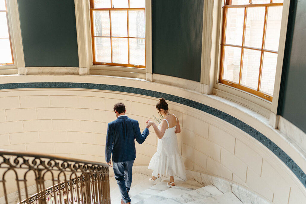 A couple on the stairs at city hall in portland Maine during their elopement.