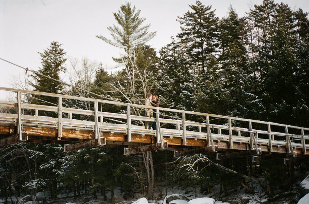 A couple posing on a bridge at a river location off of the Kanc in the White Mountains