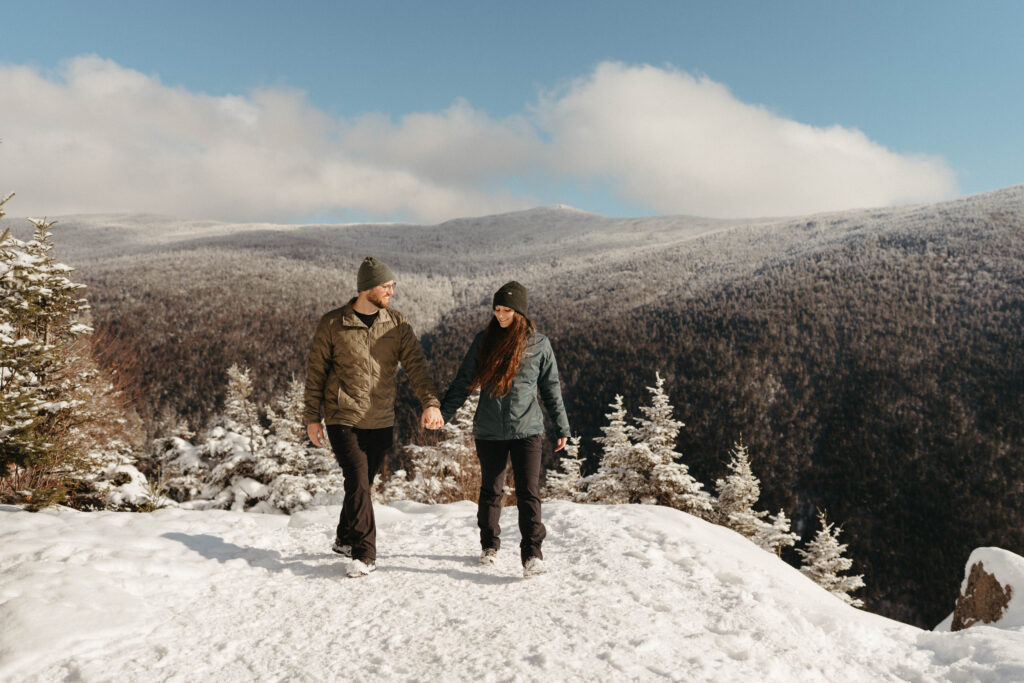 A couple walking after getting proposed in the White Mountains on a winter hike 