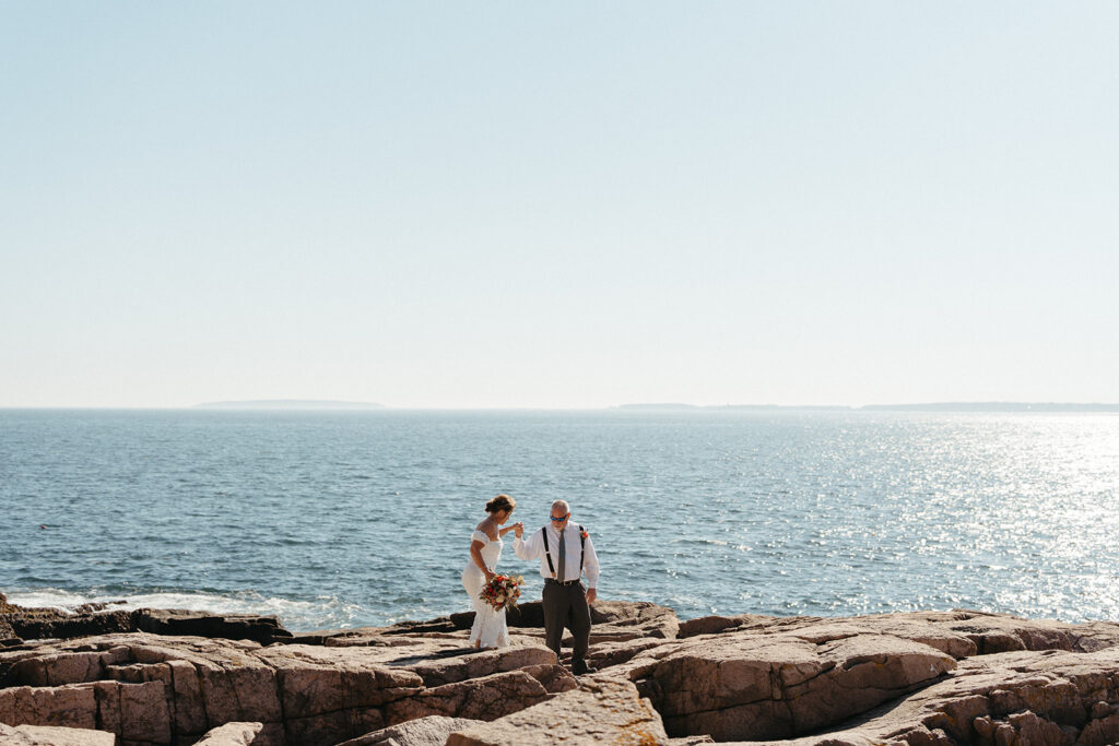A couple exploring at Otter Point in Acadia National Park during their elopement. 