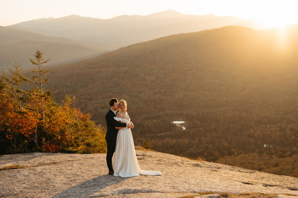 A couple on a mountain at sunrise for their Crawford Notch elopement