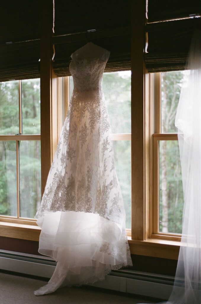 The brides dress hanging up in a window