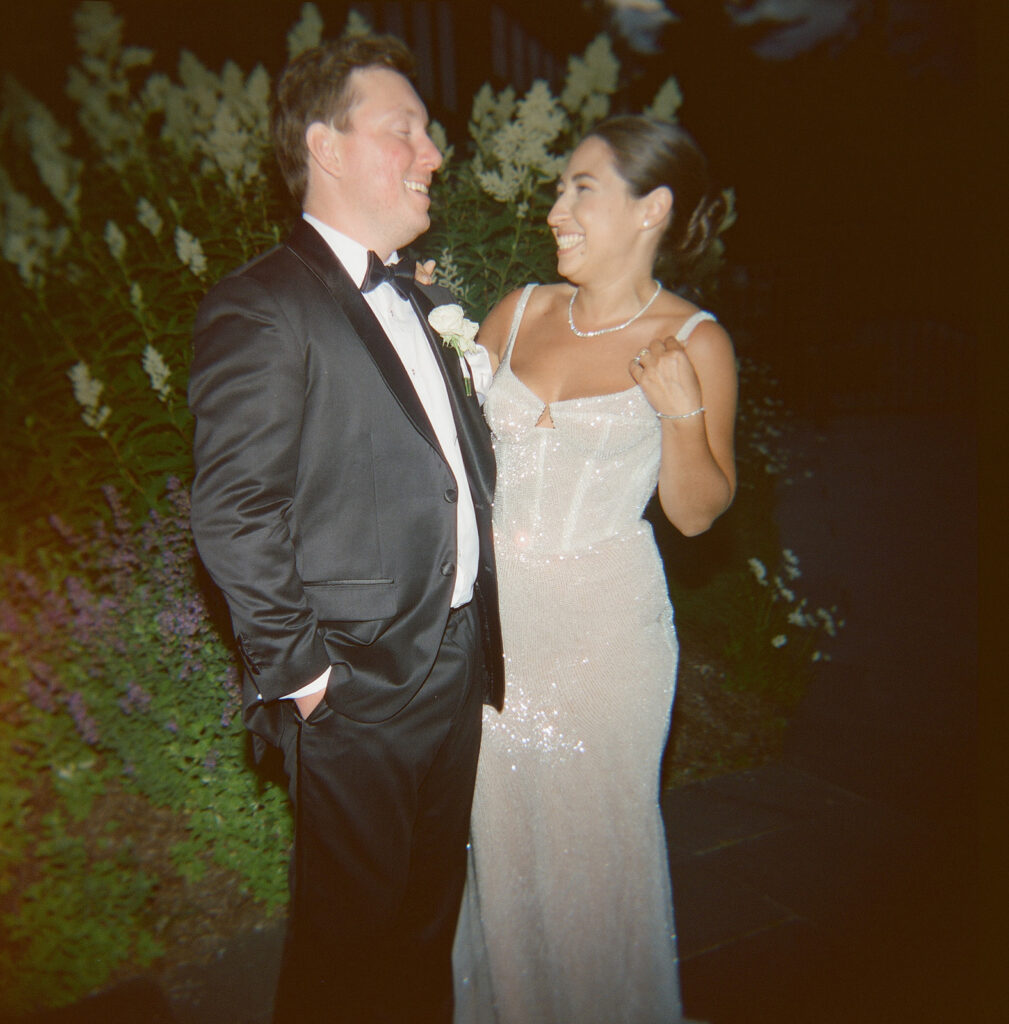The bride and groom laughing in a flash photo. 