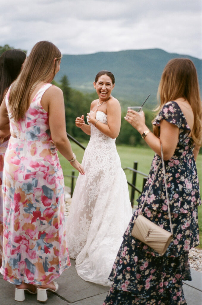 The bride during cocktail hour laughing with the mountains of Vermont in the background