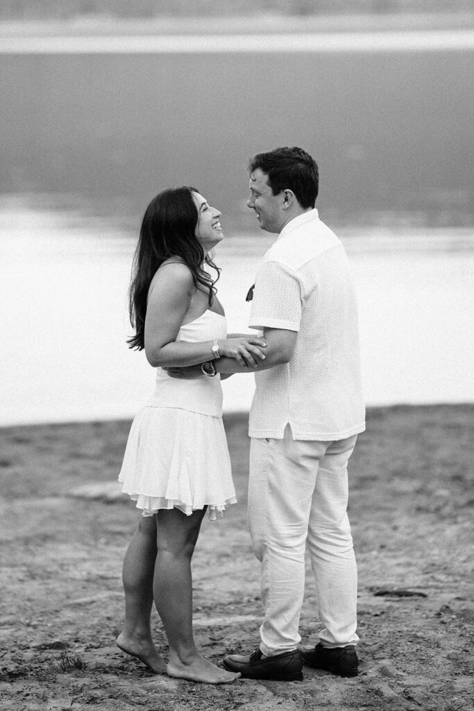 The bride and groom in black and white down by the lake. 
