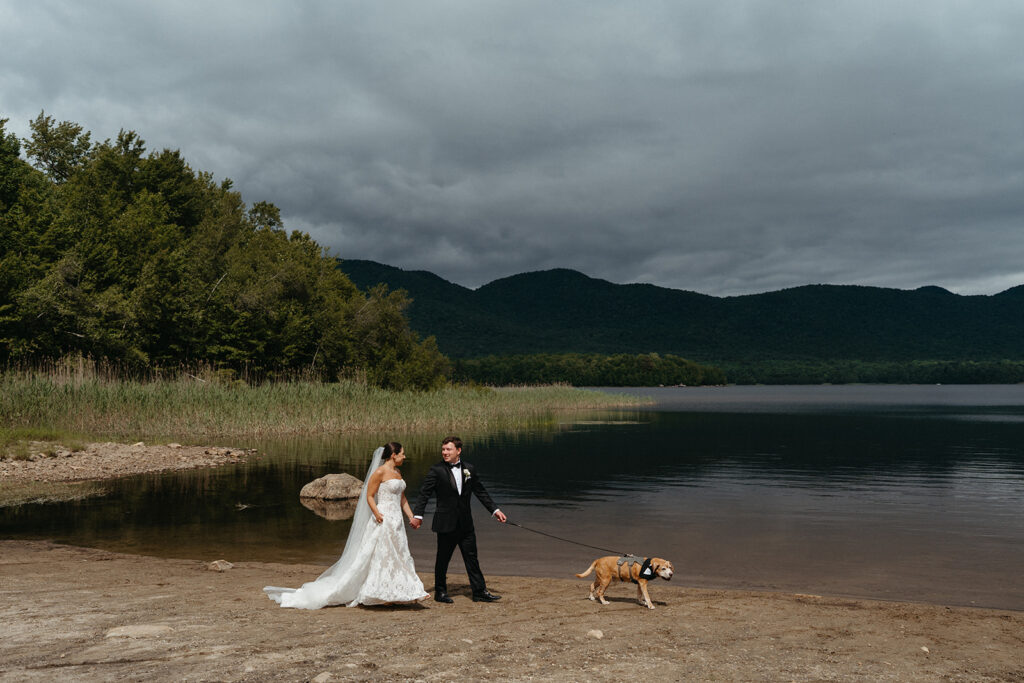 The couple and their dog walking in front of the lake at Mountain Top Resort 