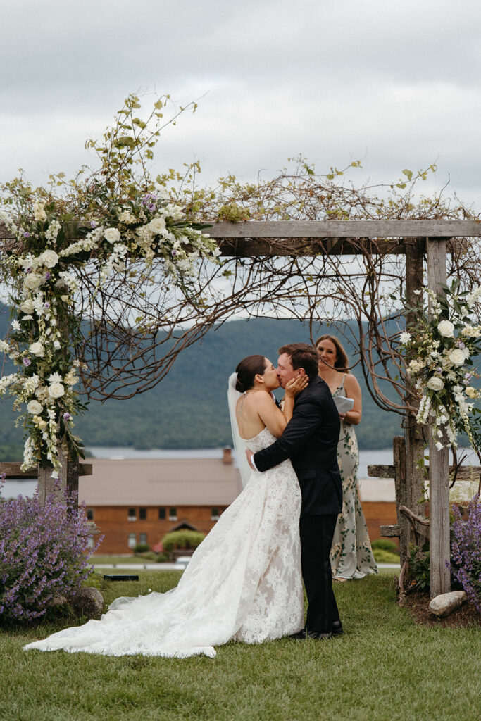 The bride and grooms first kiss under a beautiful arbor at Mountain Top Resort. 
