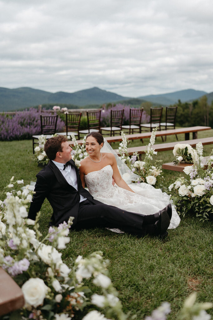The couple sitting in the flower lined aisle of the ceremony space after everyone had gone to cocktail hour. 