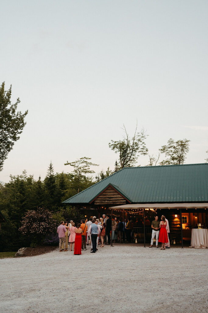 The Lakefront Pavillion at Mountain Top Resort from the outside with people standing in front of it. 