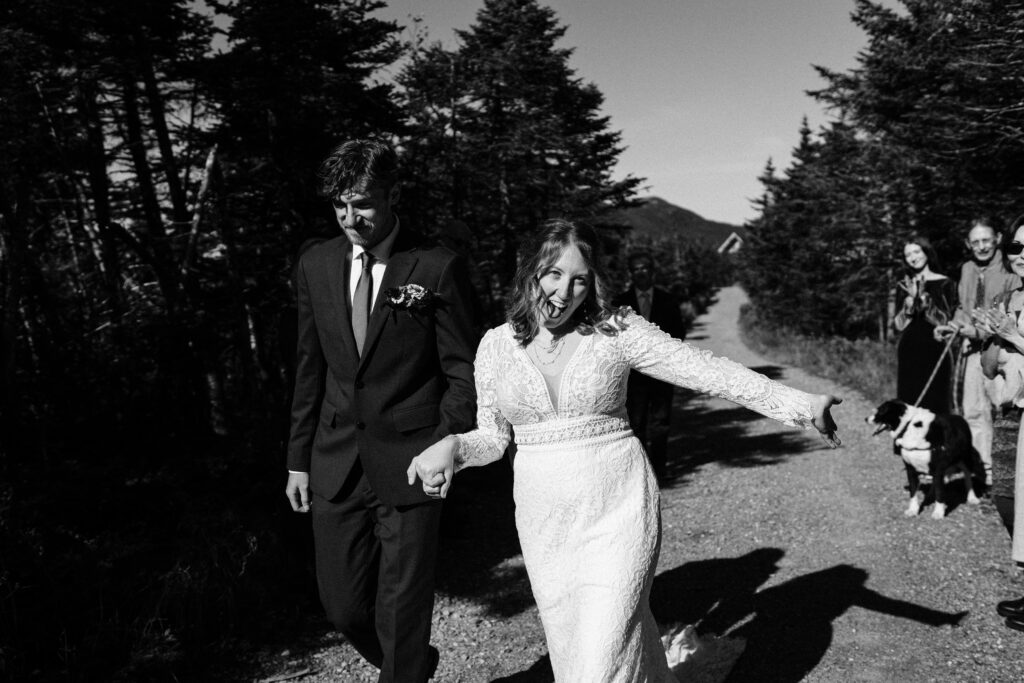 The bride smiling at the camera after getting married on Mount Mansfield in black and white. 