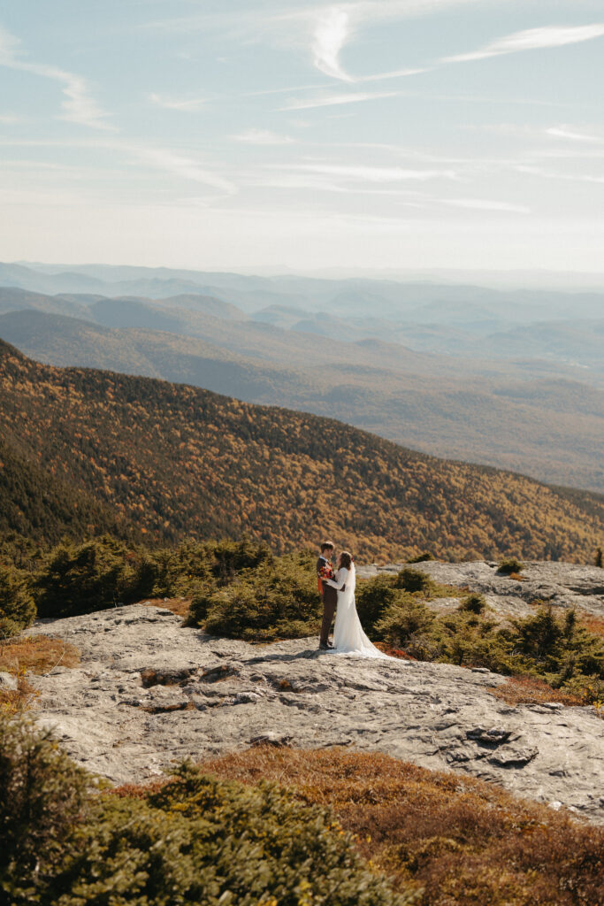 The couple embracing on Mount Mansfield for their adventurous elopement portraits. 