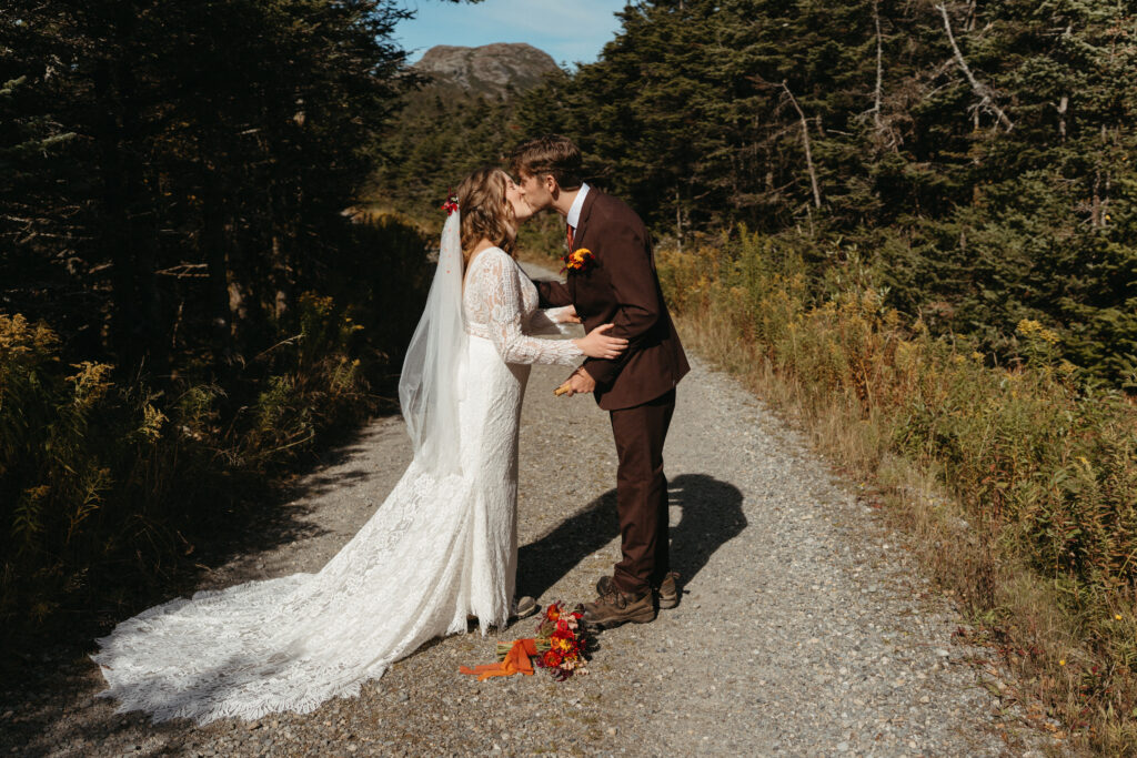 A couple kissing on a gravel road on Mount Mansfield in Vermont. 